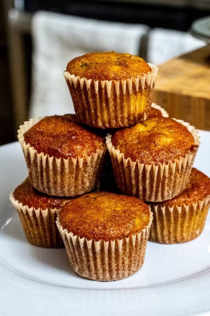 almond flour banana muffins stacked on top of each other on a white plate
