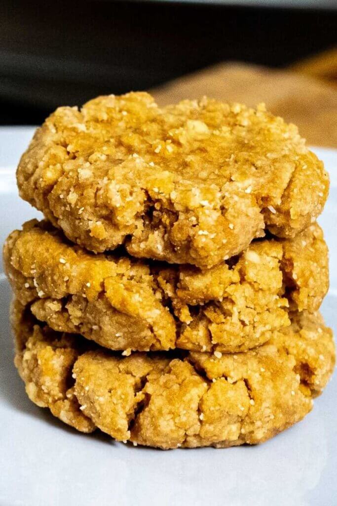 a stack of three almond flour peanut butter cookies on a white plate