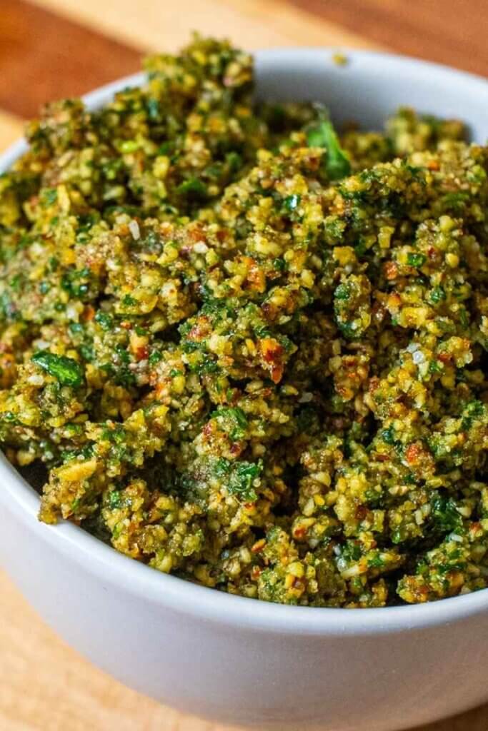 close up of almond pesto in a white bowl on a cutting board