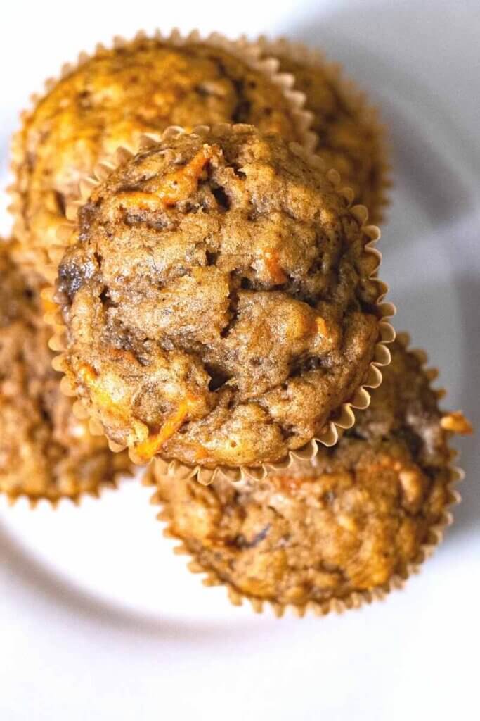 top shot of a stack of banana carrot muffins on a white plate