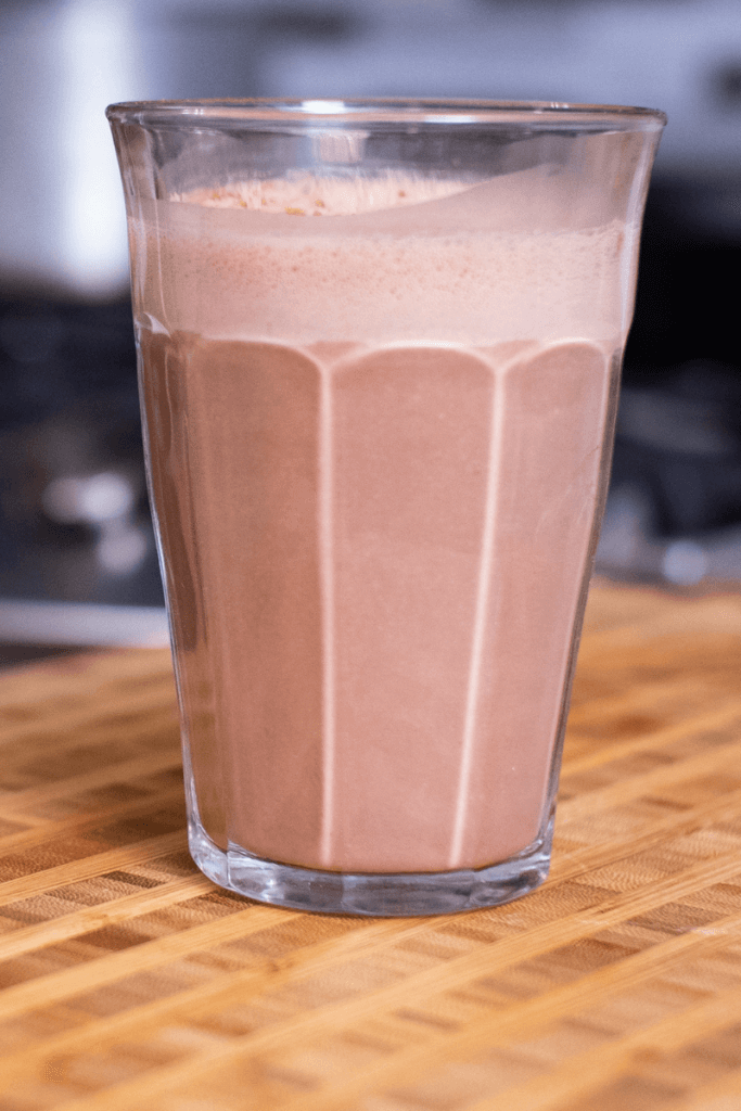 side shot of a glass filled with chocolate cashew milk that is homemade