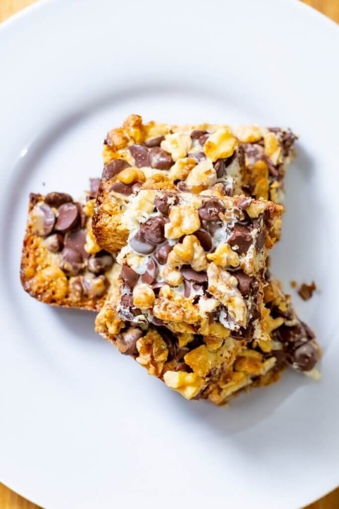 top view of a stack of 7 layer hello dolly bars on a white plate