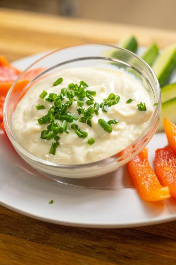vegan garlic aioli in a bowl on a plate with veggies