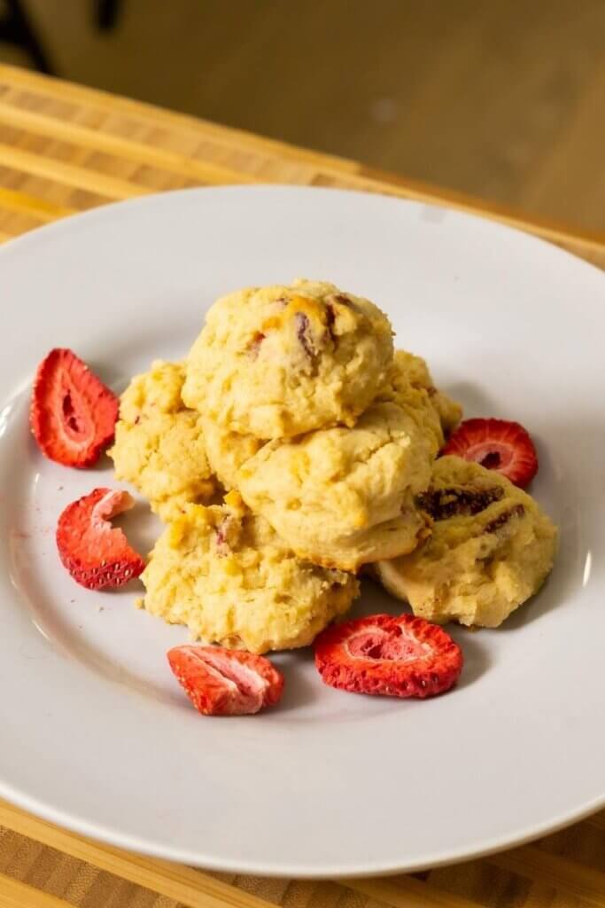 a stack of strawberry cream cheese cookies on a plate with freeze dried strawberries