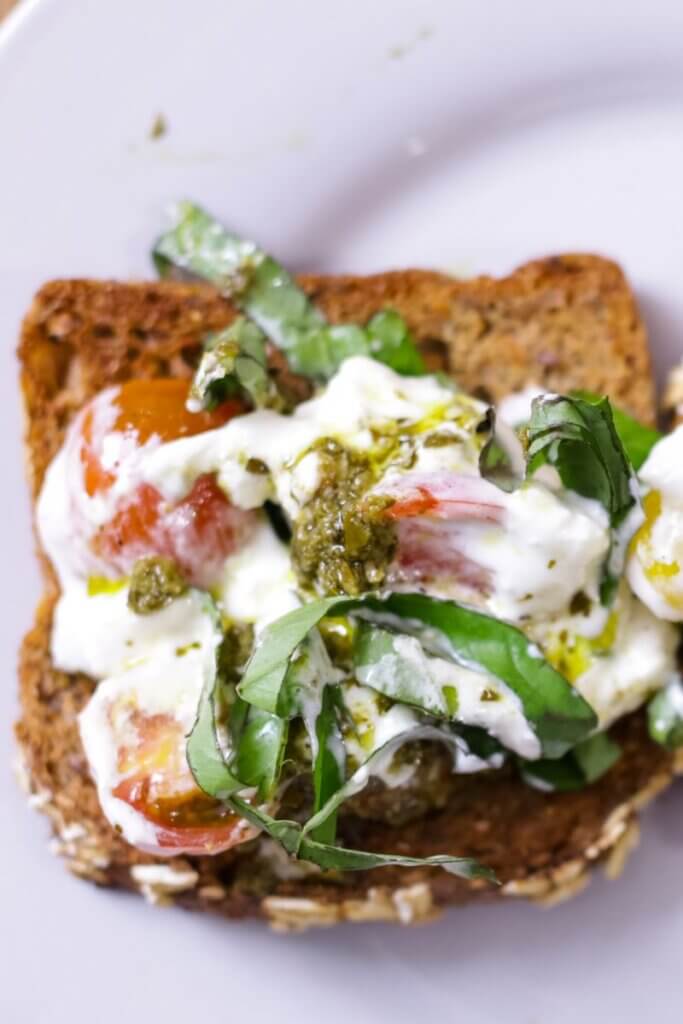 top view of burrata pesto toast with basil
