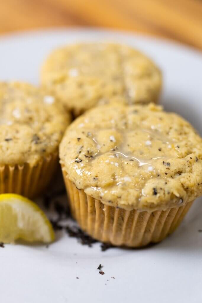 side view of three Earl grey cupcakes next to a lemon wedge.