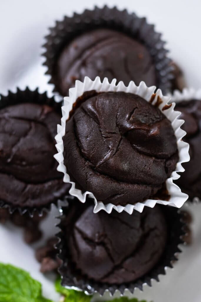 top view of a stack of black bean brownies on a plate in muffin liners.