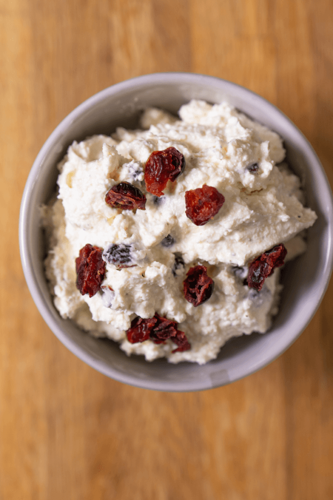 Top view of homemade whipped cranberry feta dip in a small white bowl.