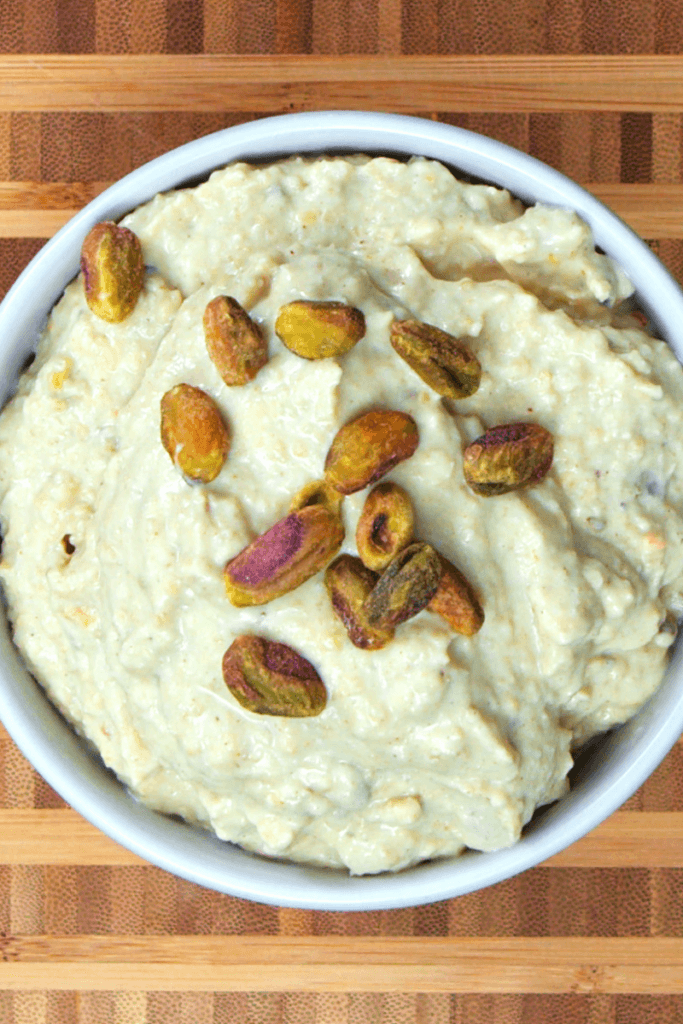 Top view of a bowl of pistachio hummus top with more pistachios.