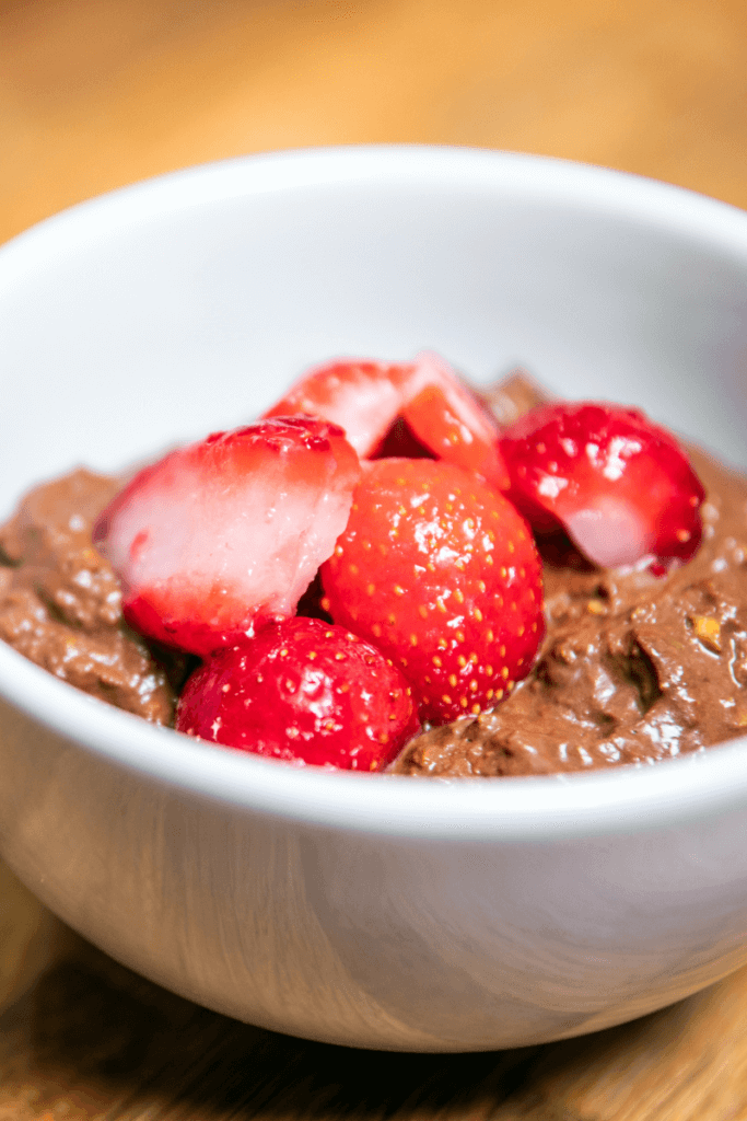 Avocado chocolate mousse in a small bowl with berries.