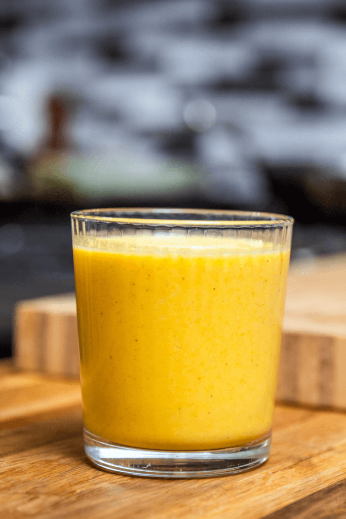 Golden milk smoothie in a small glass.
