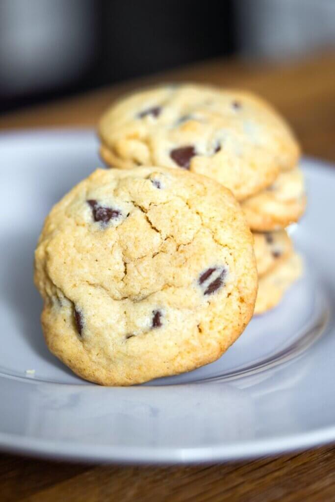 Close up of homemade bacon grease chocolate chip cookies on a white plate.