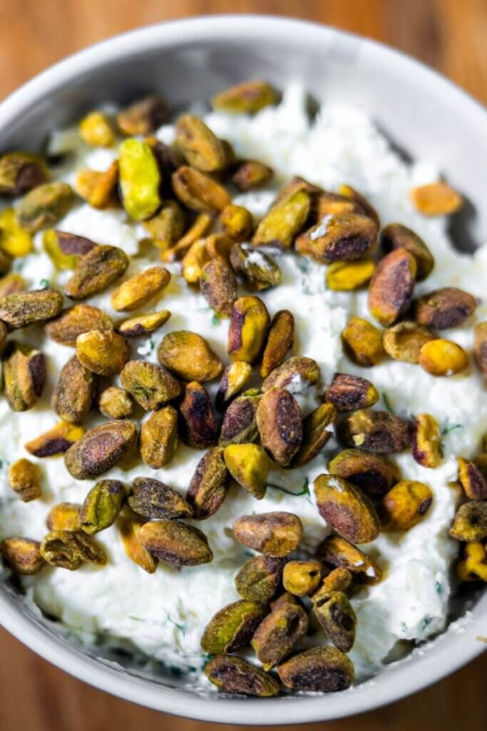 A large bowl of pistachio cheese dip topped with toasted pistachios.