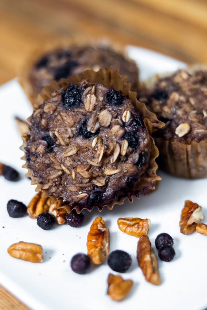 Fresh vegan oatmeal muffins with pecans on a white plate.